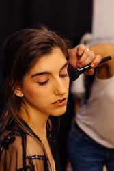 Makeup artist doing makeup for young female artist