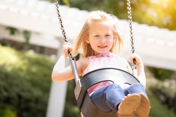 Young Girl Having Fun On The Swings At The Playground
