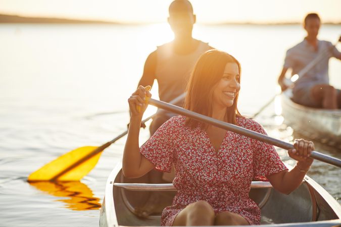 Woman smiling while rowing a canoe on a summers’ day