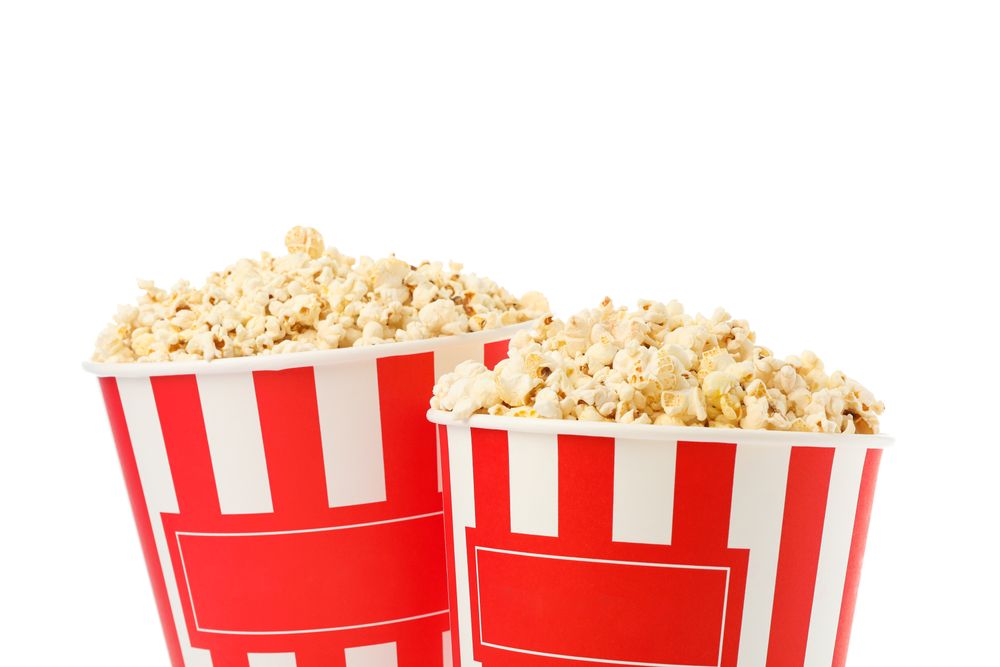 Striped buckets with popcorn isolated on plain background