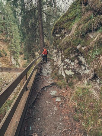 Man taking photo while walking on footpath