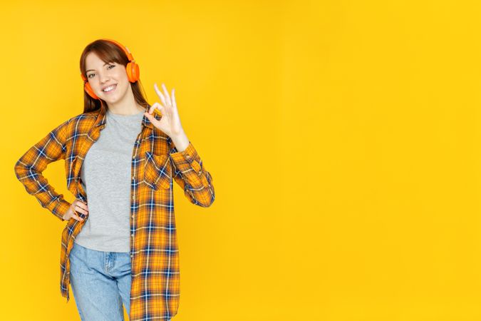 Concept of people, woman with headphones on yellow background