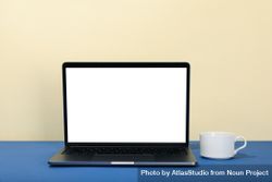 Open laptop with blank mockup screen in cream and blue with cup 4ZWxNb