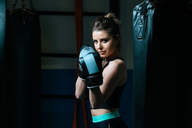 Sportswoman in boxing gloves in gym