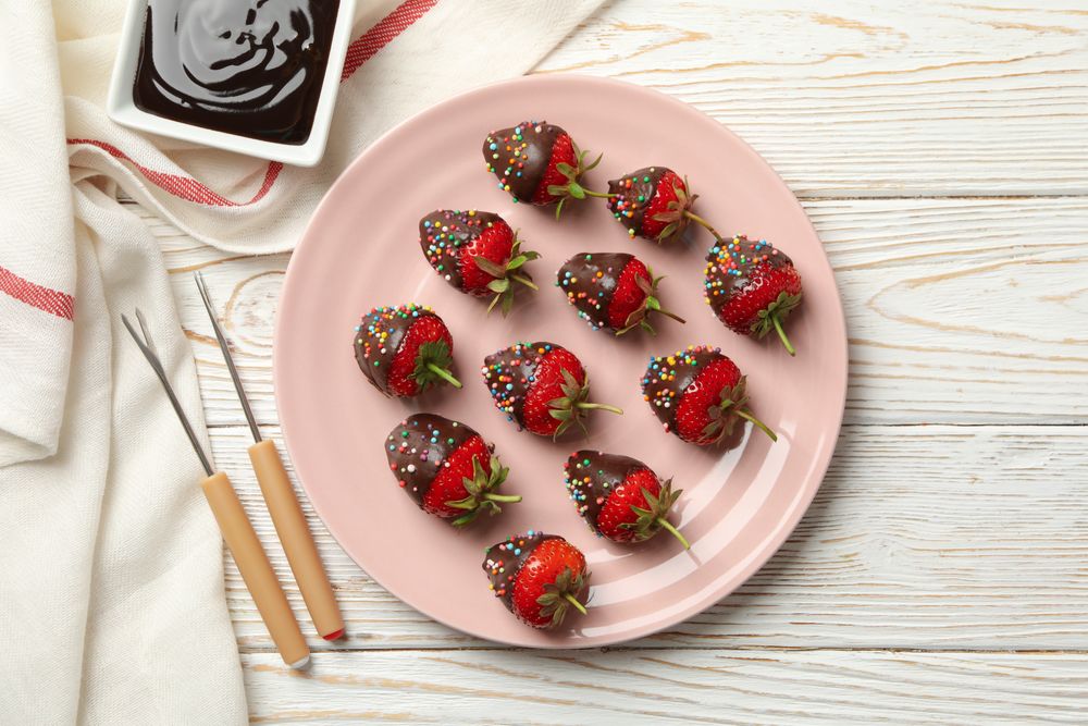 Chocolate fondue. Strawberry in chocolate on wooden background