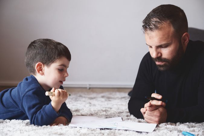 Father and son drawing on floor
