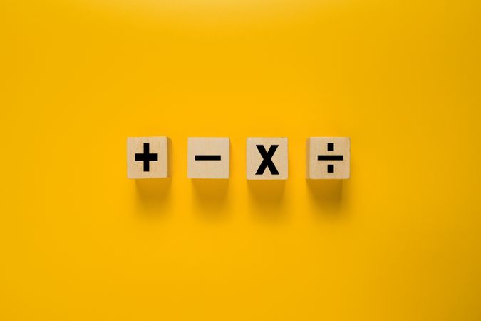 basic mathematic operation symbol on wooden blocks isolated on yellow background