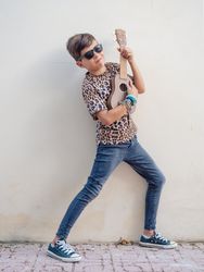 Excited kid raising hands up with ukulele