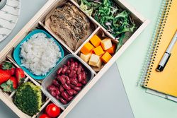 Food box with diet ingredients by copybook and plate
