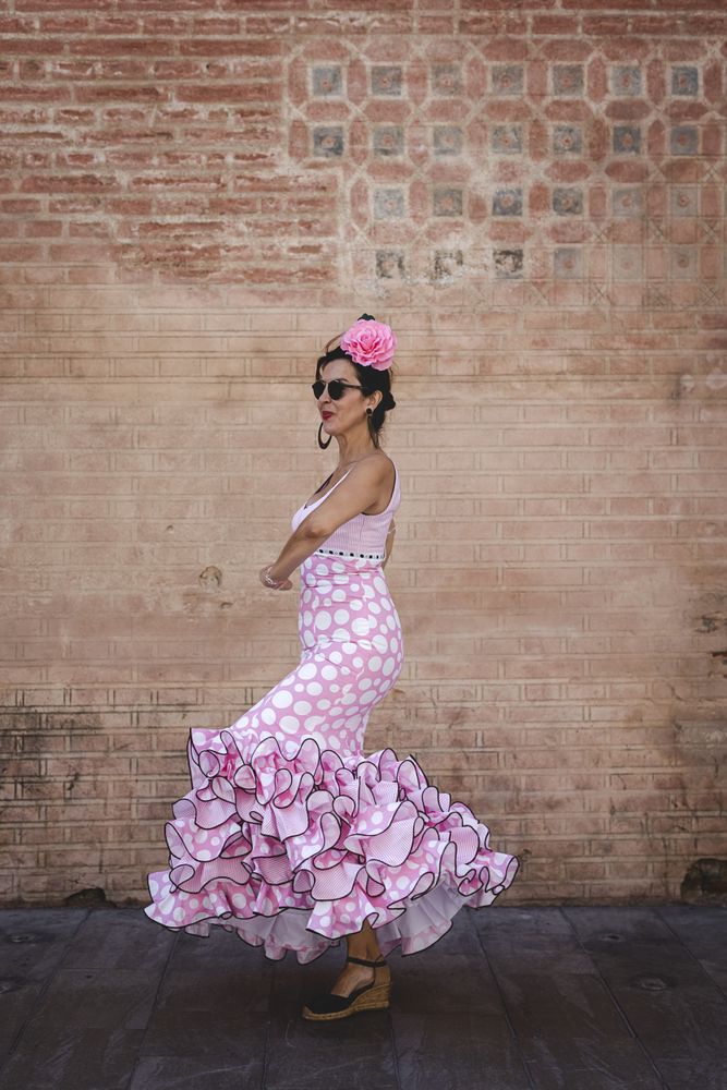 Passionate woman in flamenco dress dancing on street