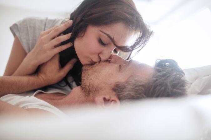 Close up of man and woman being romantic and kissing in bed
