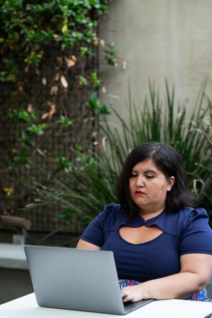 Woman working on laptop on table outside