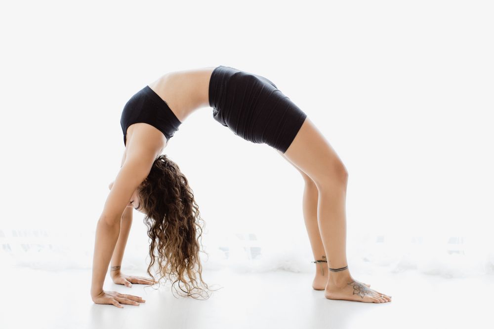 Sportive woman performing yoga pose in room