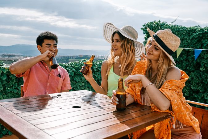 a group of young people having a good time in a summer day and cheering with beer