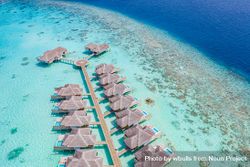 Drone shot of two rows of overwater bungalows in the Maldives 4A6YQb