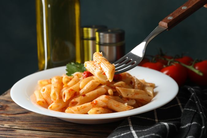 Composition with plate of tasty pasta on wooden background, close up