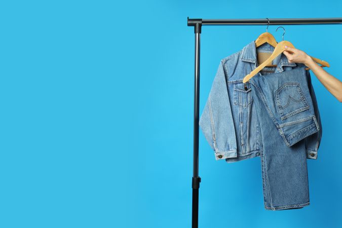 Jeans hang on hangers on a blue background