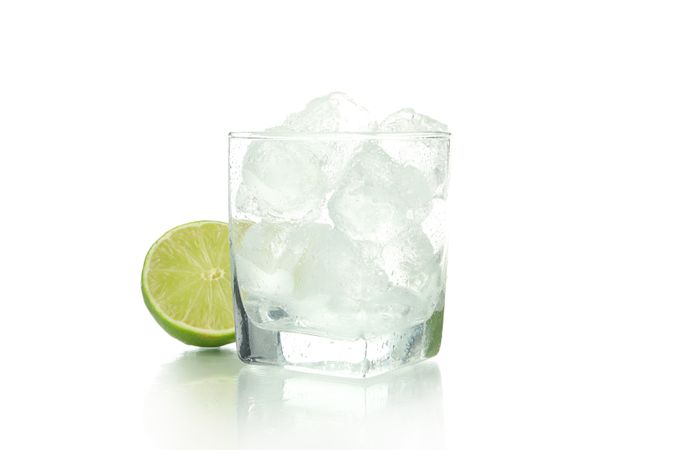 Rocks glass full of ice with a lime half