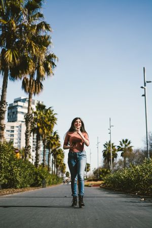 Teen girl walking happily through the streets.