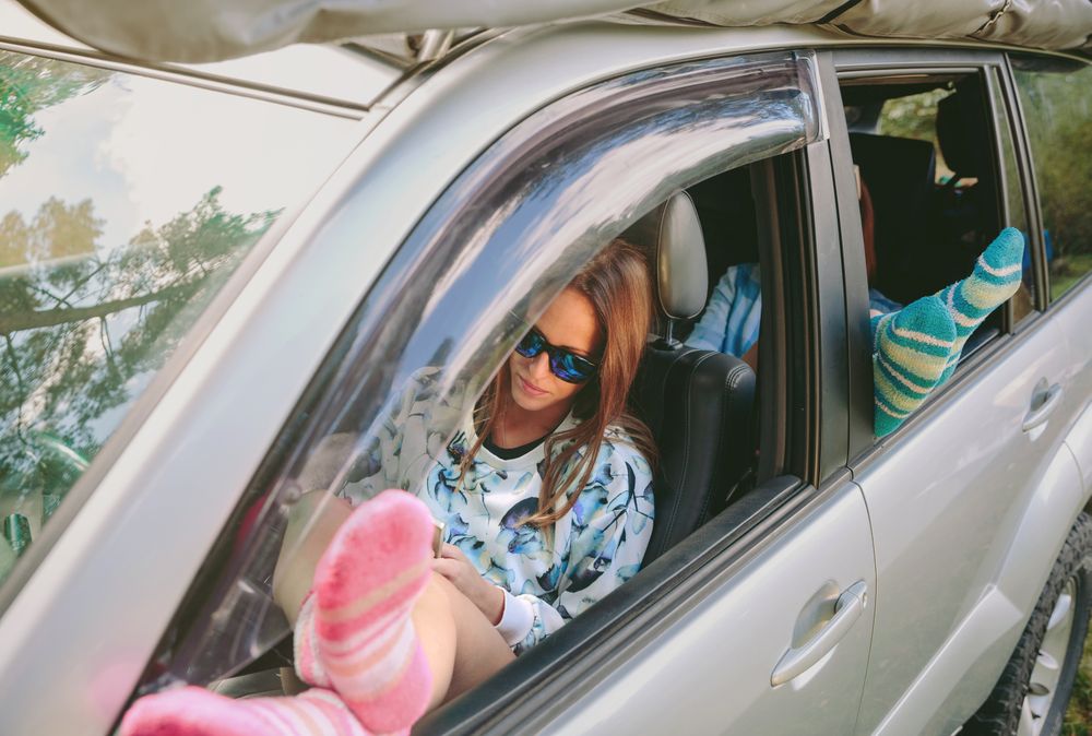 Women resting with her legs over open window car