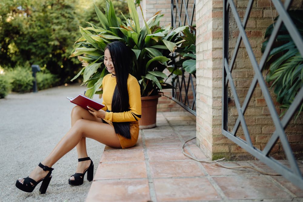 Asian woman reading book on the street
