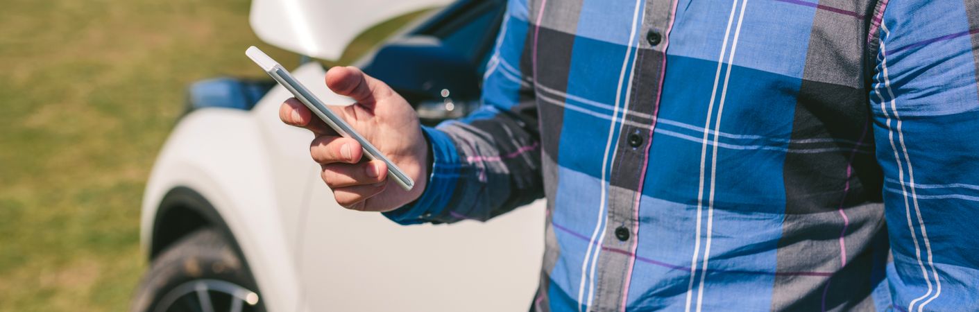 Young man with broken down car calling by mobile