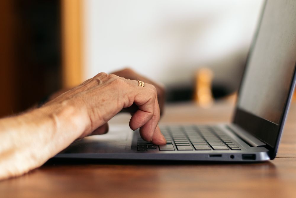 Unrecognizable older woman using the laptop