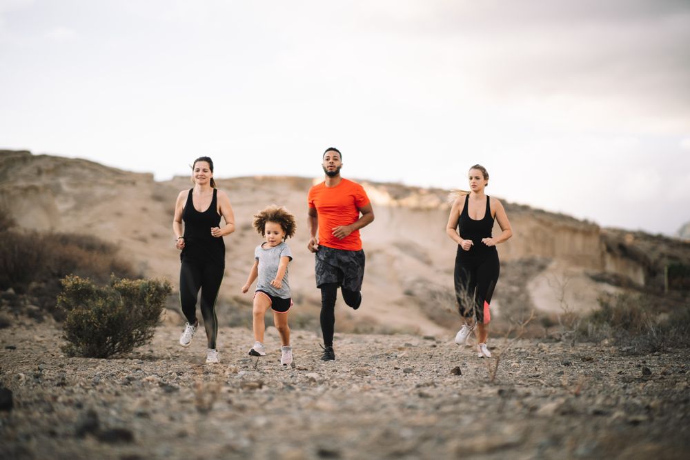 Active diverse family running on nature