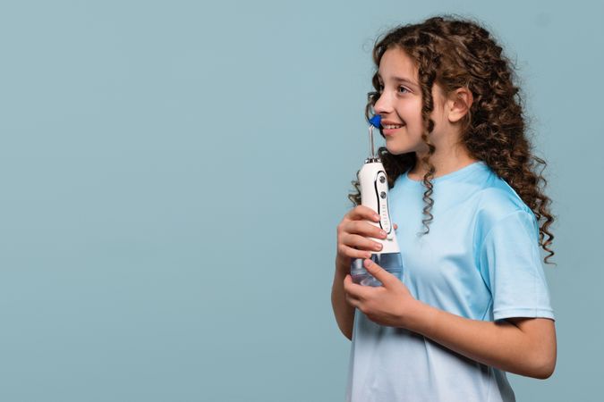 Girl smiling while using an oral irrigator