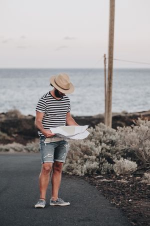 Male traveler standing with map