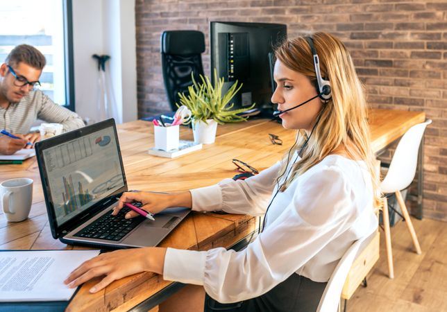 Young woman with headset in customer service of coworking