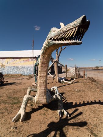 Dragon statue in dirt lot in Arizona desert