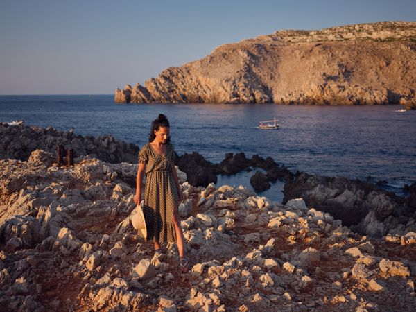 Woman walking along seashore near water