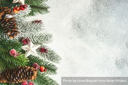 Christmas branch, pine cones, ornaments and holly on grey background with copy space bePkA4