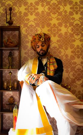 Portrait of an Indian man wearing turban and lungi indoor