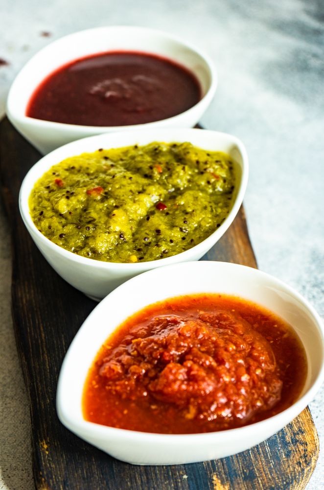 Three flavorful spicy traditional Georgian sauces on wooden board