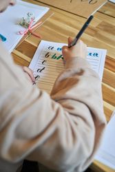 Crop artist practicing lettering sitting at wooden table