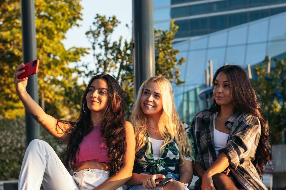 Female friends taking selfies outdoors