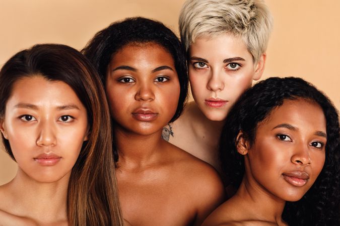 Portrait of a multi-ethnic group of women in a peach studio shoot