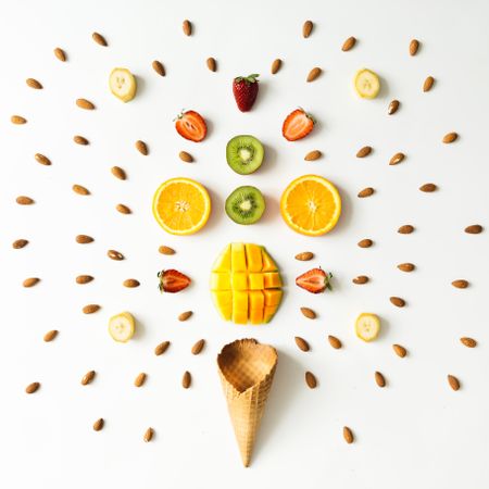 Symmetrical layout of fresh fruits, nuts and ice cream cone