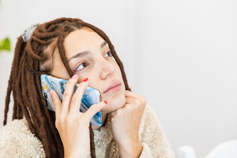 Close-up of a woman with braids using the mobile
