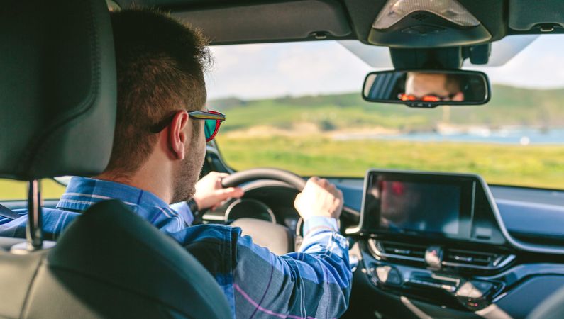 Young man holding steering driving