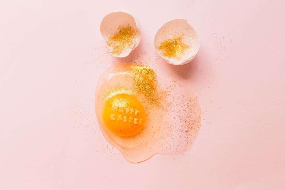 Fresh broken chicken egg covered with glitter with eggshell
