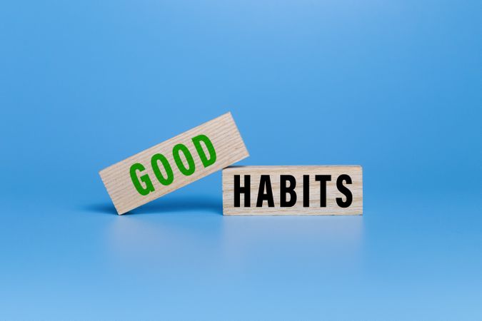 good habits words symbol on wooden blocks isolated on white ang green background. motivational words concept
