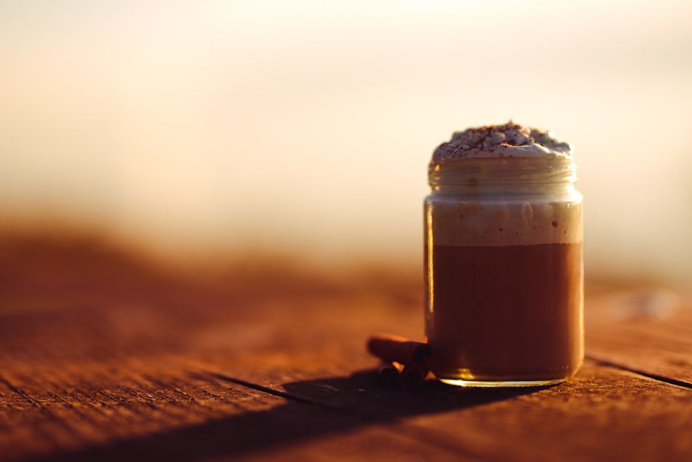 Cinnamon near coffee on table