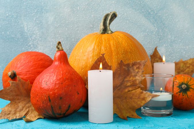 Composition with pumpkins and candles on wooden background, space for text