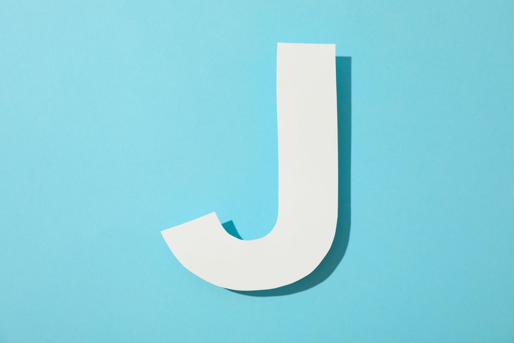 Paper letter J on color background, space for text