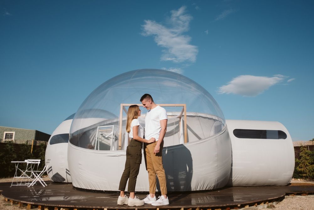 Affectionate couple looking at each other near bubble hotel
