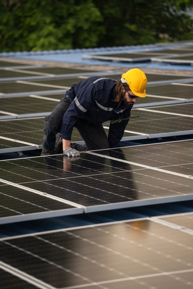 Engineer worker using electric drill repairing on solar cell panel on the roof of the factory. After service and security for industrial renewable energy concept
