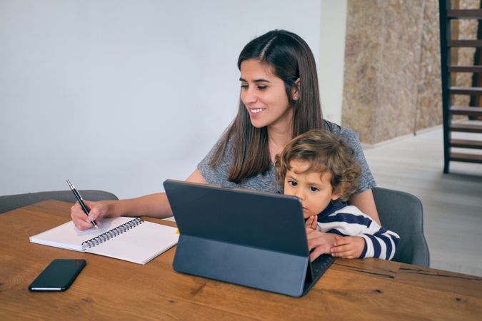 Mother and son using laptop at home
